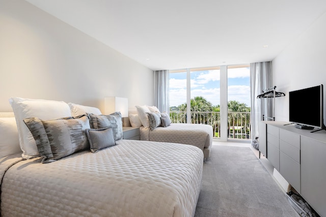 carpeted bedroom featuring access to exterior and a wall of windows