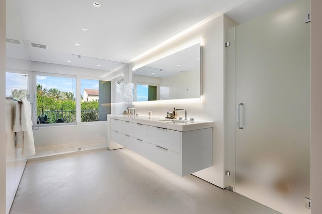 bathroom with concrete flooring, vanity, and a shower with shower door