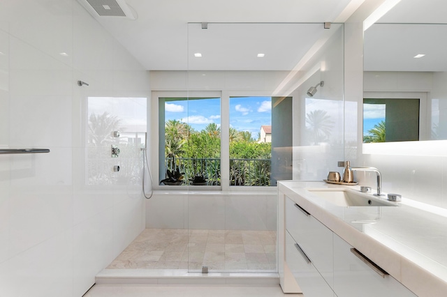 bathroom with vanity, a shower with door, and a healthy amount of sunlight