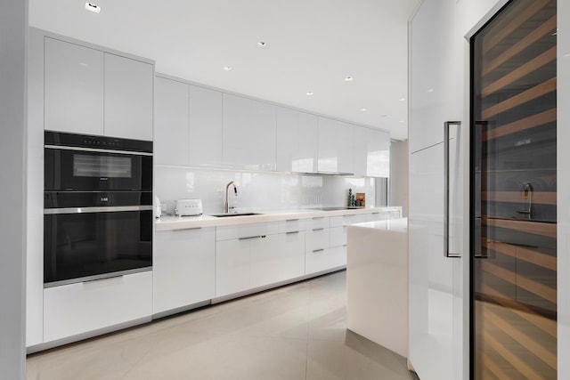 kitchen featuring white cabinetry, sink, wine cooler, decorative backsplash, and light tile patterned floors