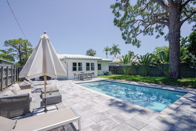 view of swimming pool featuring outdoor lounge area, a patio, and a fenced backyard