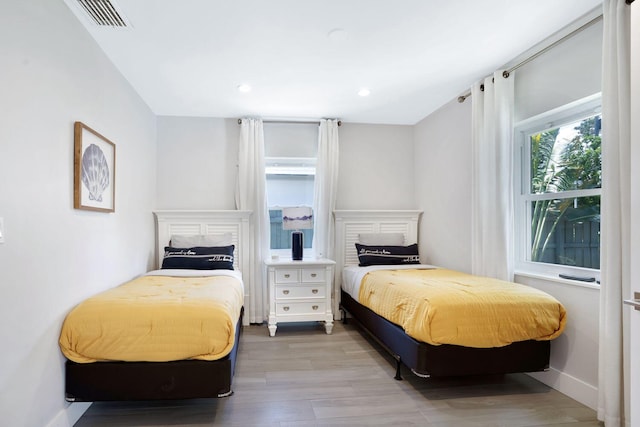 bedroom featuring visible vents, baseboards, recessed lighting, and wood finished floors