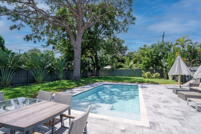 view of swimming pool featuring a fenced in pool, a patio area, outdoor dining area, a fenced backyard, and a yard