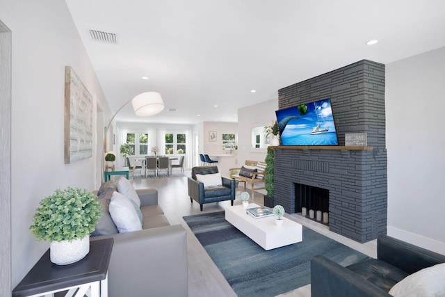 living area with visible vents, recessed lighting, arched walkways, and a fireplace