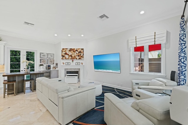 living room with a high end fireplace and ornamental molding