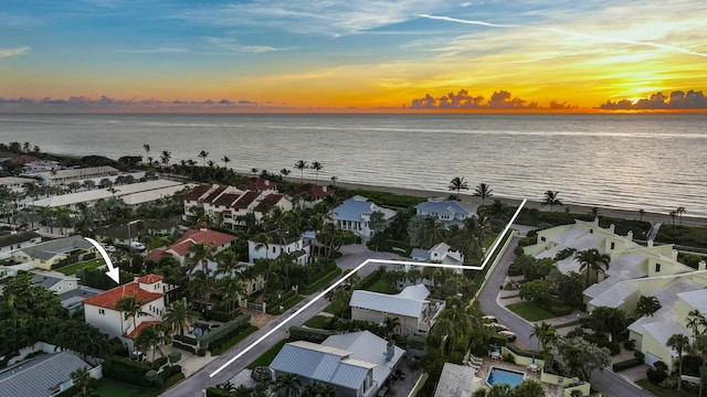 aerial view at dusk featuring a water view