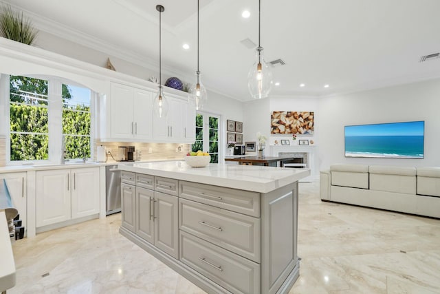 kitchen with white cabinetry, tasteful backsplash, light stone counters, pendant lighting, and a kitchen island