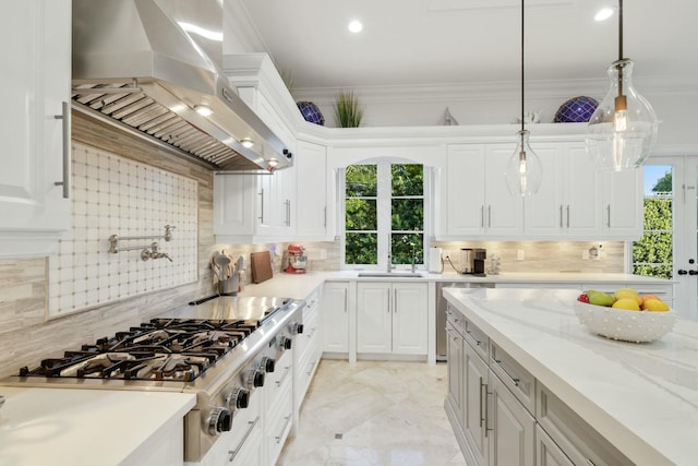 kitchen with white cabinets, wall chimney exhaust hood, and pendant lighting