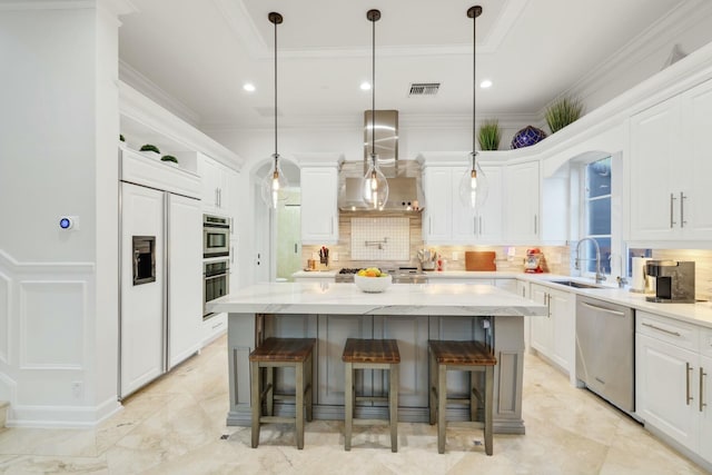 kitchen featuring a center island, stainless steel appliances, and wall chimney exhaust hood