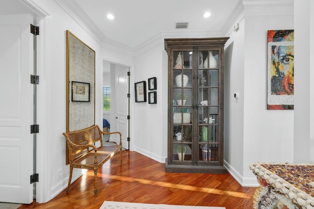 sitting room featuring wood-type flooring and ornamental molding