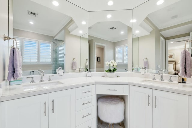 bathroom with vanity, a shower with door, and ornamental molding