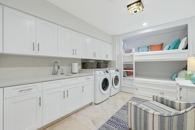 laundry room with washer and clothes dryer, cabinets, and sink