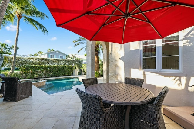 view of swimming pool featuring a patio area and an in ground hot tub