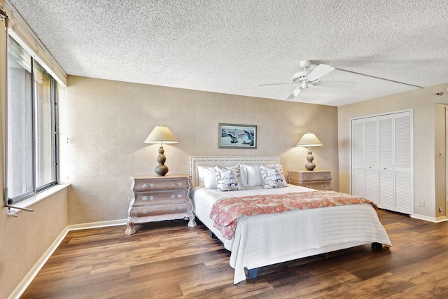 bedroom featuring a textured ceiling, dark hardwood / wood-style floors, ceiling fan, and a closet