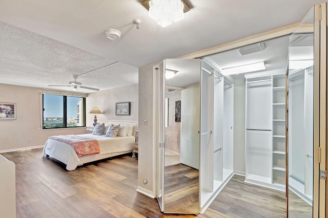 bedroom with wood-type flooring, a textured ceiling, and ceiling fan