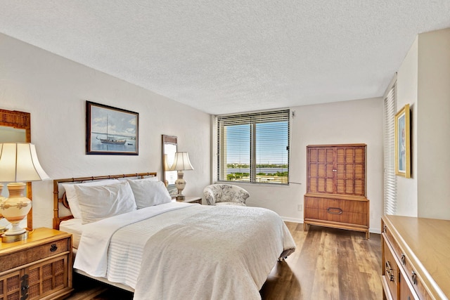 bedroom featuring a textured ceiling and dark wood-type flooring