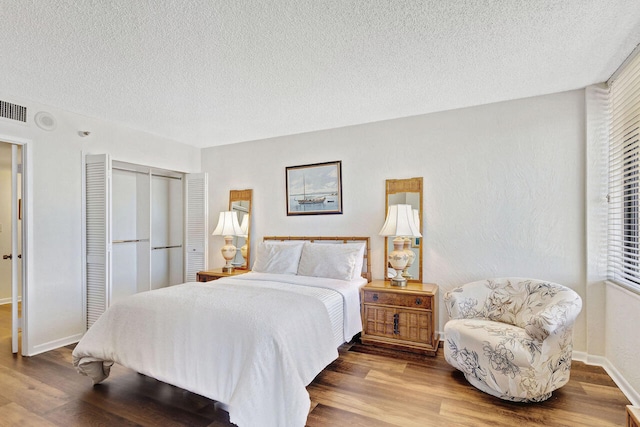 bedroom featuring a textured ceiling, a closet, and hardwood / wood-style floors