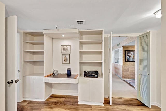 office space with light hardwood / wood-style flooring and built in desk