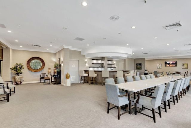 dining room featuring light carpet and crown molding