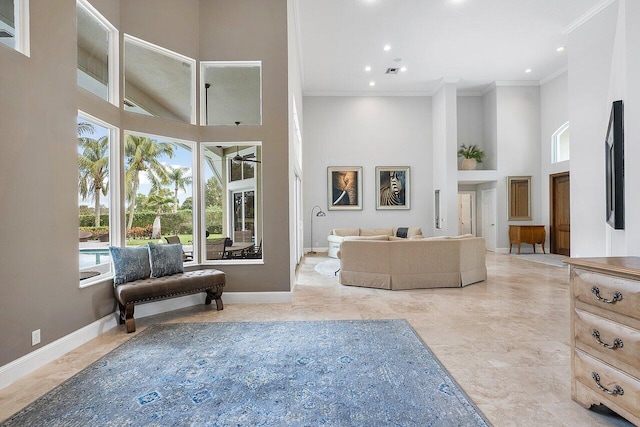 living room with a high ceiling and ornamental molding