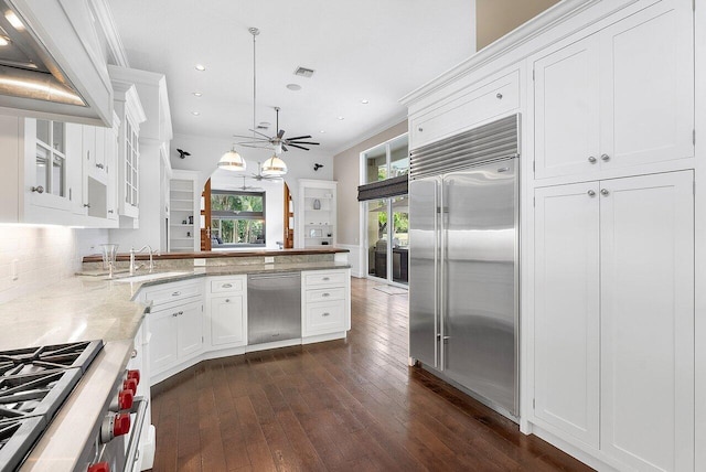 kitchen with ceiling fan, hanging light fixtures, ornamental molding, white cabinetry, and high quality appliances