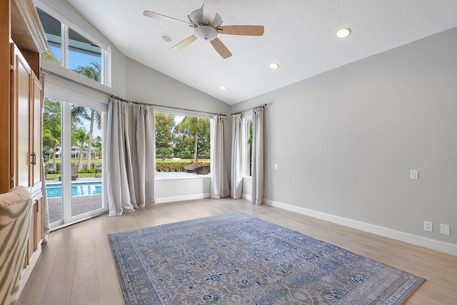 unfurnished room featuring light hardwood / wood-style flooring, a wealth of natural light, ceiling fan, and a textured ceiling