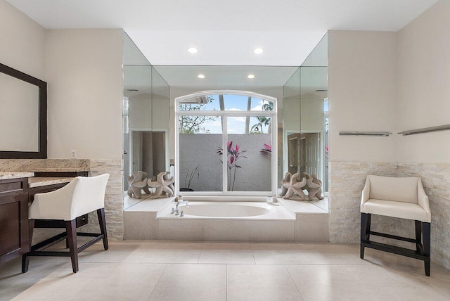 bathroom with tile patterned flooring, vanity, and a relaxing tiled tub