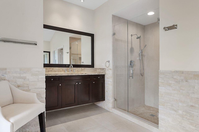 bathroom with walk in shower, tile walls, tile patterned flooring, and vanity