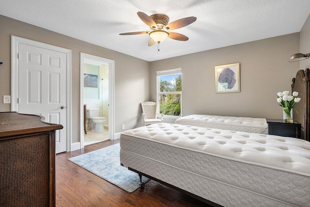 bedroom featuring ceiling fan, a textured ceiling, ensuite bath, and dark hardwood / wood-style floors