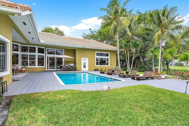 view of pool with a lawn and a patio area