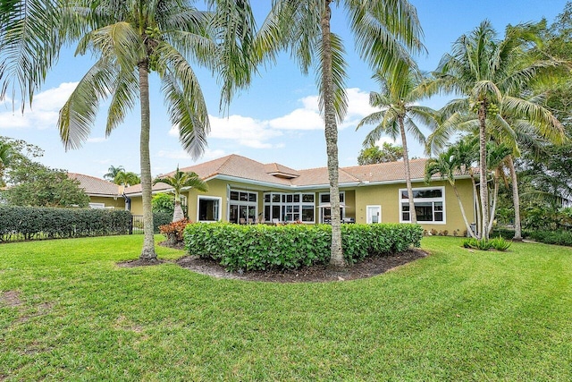 rear view of property featuring a lawn