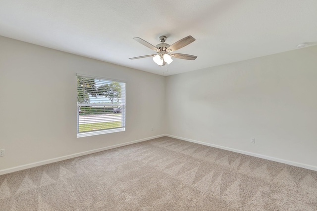 empty room featuring ceiling fan and carpet