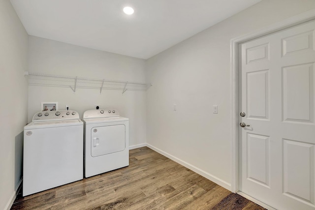 clothes washing area featuring hardwood / wood-style floors and washing machine and dryer