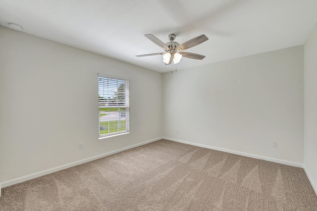 carpeted spare room featuring ceiling fan