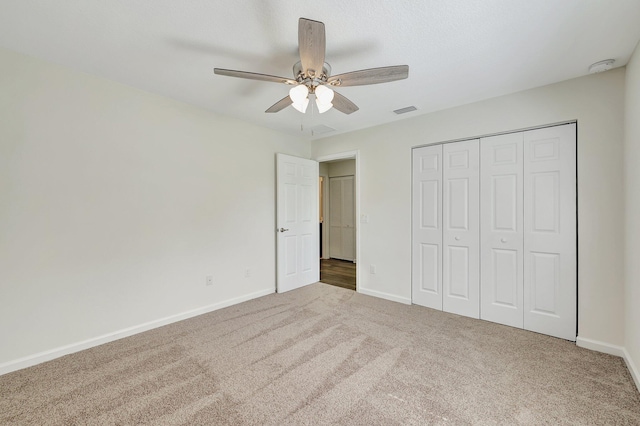 unfurnished bedroom featuring a closet, carpet, and ceiling fan