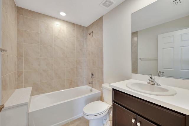 full bathroom with tile patterned flooring, tiled shower / bath combo, vanity, and toilet