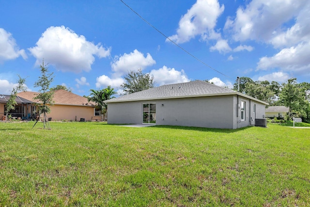 rear view of house with a lawn and central air condition unit