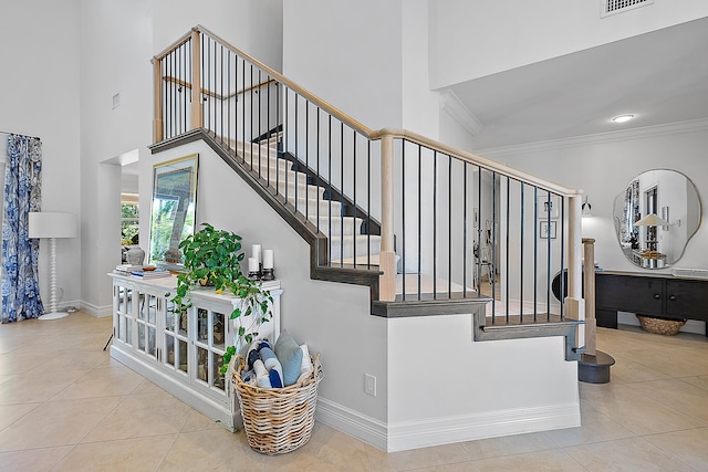 stairs featuring tile patterned floors and crown molding