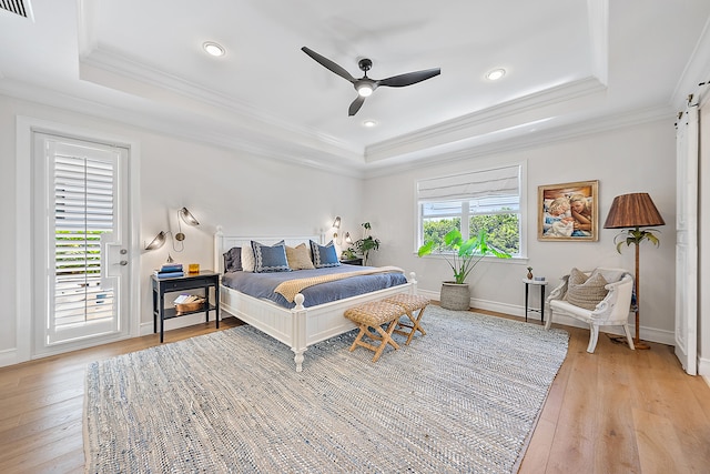 bedroom with a raised ceiling, access to exterior, ceiling fan, and light wood-type flooring