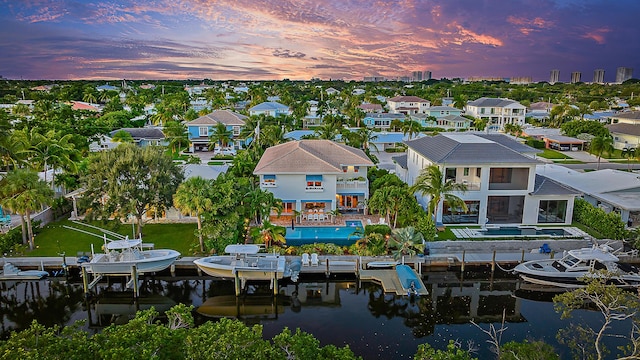 aerial view at dusk featuring a water view