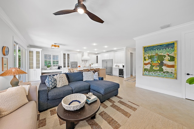 living room with ceiling fan, light tile patterned flooring, and ornamental molding