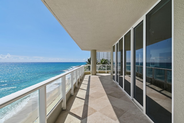 balcony featuring a water view and a view of the beach