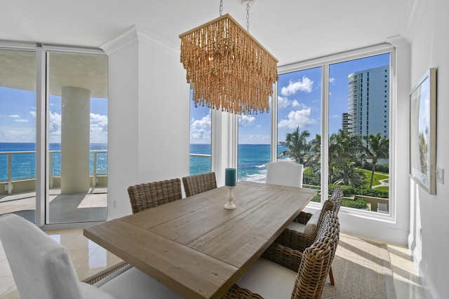 dining room with an inviting chandelier, plenty of natural light, ornamental molding, and a water view