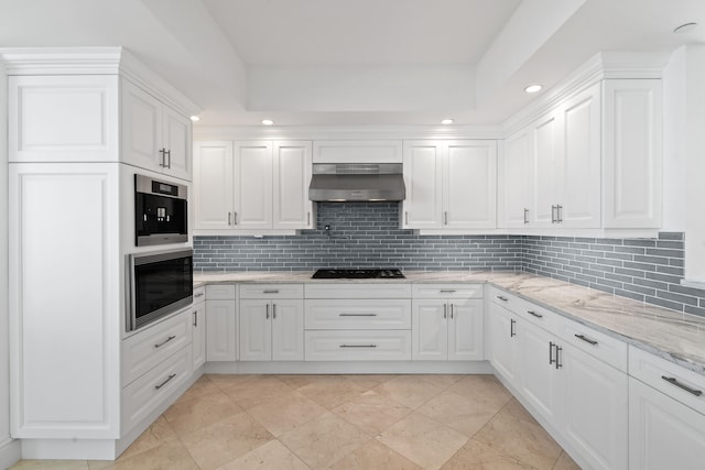 kitchen featuring white cabinetry, tasteful backsplash, light stone countertops, range hood, and black gas cooktop