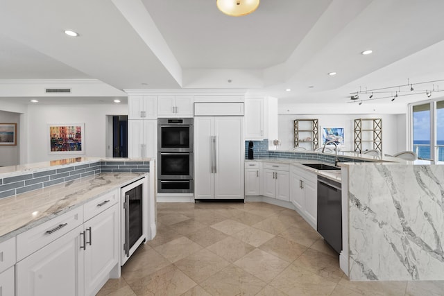 5050 N Ocean Dr Unit 402, Singer Island, FL 33404 - kitchen with double oven, beverage cooler, dishwasher, paneled fridge, and a raised ceiling