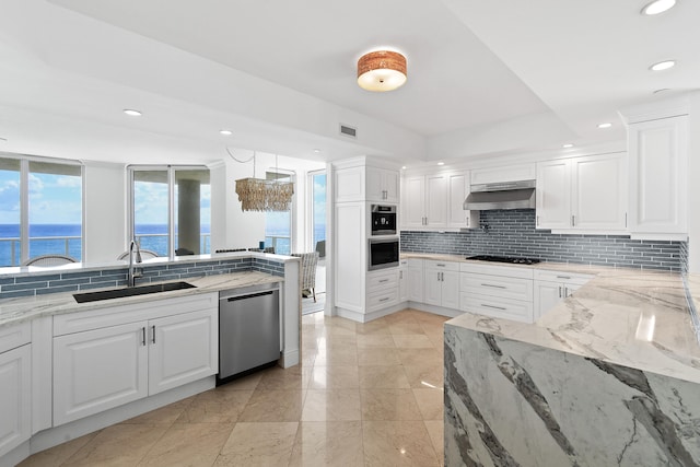 kitchen with pendant lighting, sink, white cabinetry, stainless steel appliances, and a water view