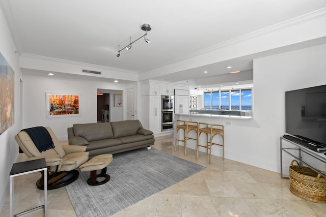 living room with washer / clothes dryer, ornamental molding, and rail lighting