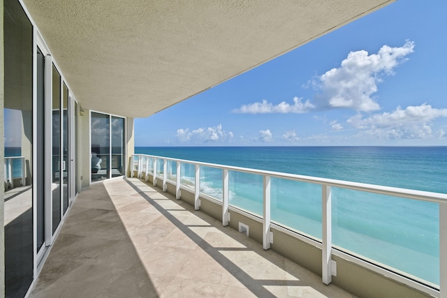 balcony featuring a water view and a beach view