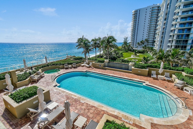 view of swimming pool featuring a patio and a water view