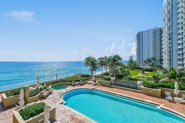 view of swimming pool with a patio and a water view